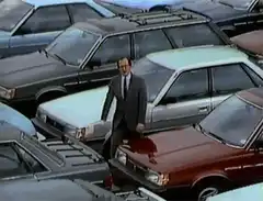 Man in suit walking through car lot