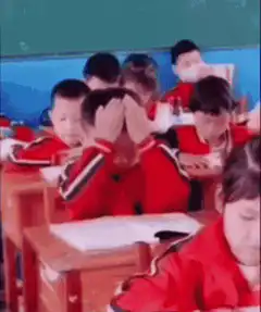 Boy rubbing eyes in class