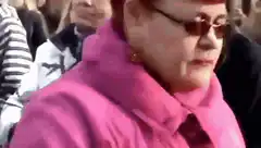 Woman in pink jacket dancing in public