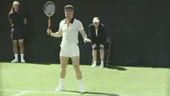 Man in vintage tennis outfit doing a funny serve