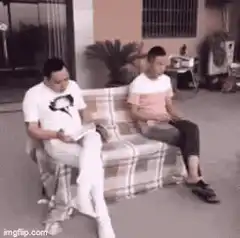 Two men on couch fall over