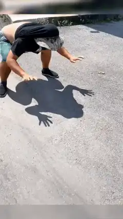 Man posing as frog shadow