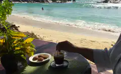 Stirring coffee on a beach