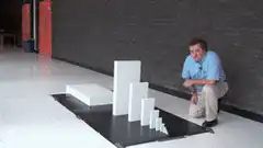 Man watching dominoes fall