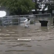 Man throws trash can in flood