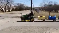 Tractor pulling train of dogs in barrels