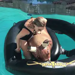 Woman riding inflatable bull in pool