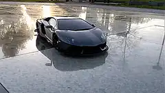 Black Lamborghini on wet pavement