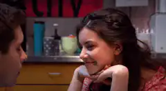 Girl smiling at boy in kitchen