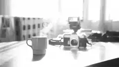 steaming coffee cup next to camera