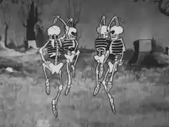 Skeletons dancing in a graveyard