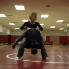 man lifting woman in wrestling gym