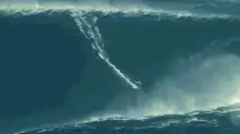 Surfer riding a massive wave