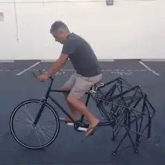 Man riding bike with folding chair attached