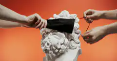 Hands putting and removing mask on statue