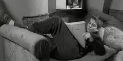 Woman reading Balzac on sofa