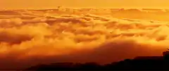 orange clouds moving over hills