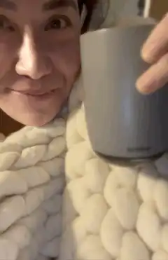 woman smiling with mug and blanket