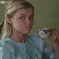 Girl sipping tea with a smirk
