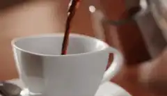 Pouring coffee into a white cup