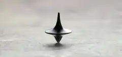 black spinning top on concrete