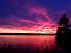 Vibrant pink and purple sunset over lake
