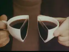 Two hands holding a split coffee cup