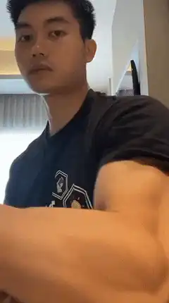 Man flexes muscular arm and drinks