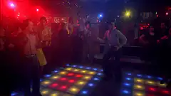 John Travolta dancing on a light-up dance floor