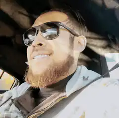 Man in sunglasses smiling in car