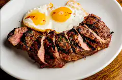sliced steak with fried eggs