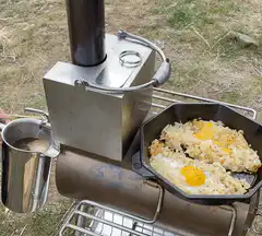 Wood stove cooking eggs and coffee outdoors