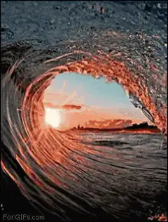 Ocean wave curling over sunset