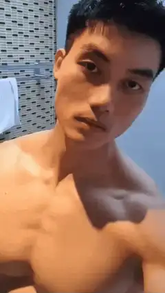 Shirtless man flexing abs in bathroom