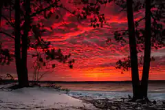 vibrant red sunset over snowy lake