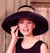 Audrey Hepburn smiling in a large hat