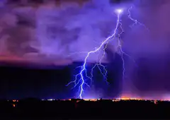 Lightning strikes over city and water