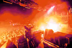 DJ performing on stage with pyrotechnics