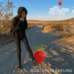 Girl Kicking Giant Strawberry in Desert