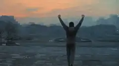person raising arms at sunset