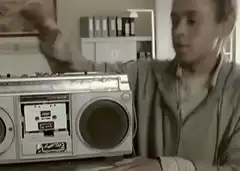 man shaking boombox to fix it