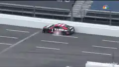 NASCAR car slides along the wall