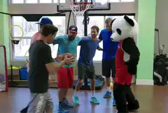 Men and panda mascot huddle