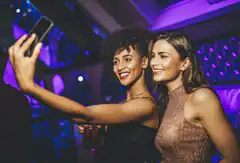 Two women taking a selfie at a club