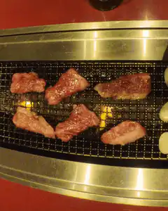 beef grilling on a metal grate