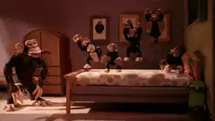 Chimpanzees jumping on a bed