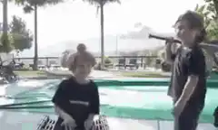 Kids playing with bat by pool