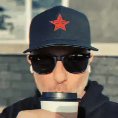 Man in cap and sunglasses drinking coffee