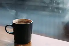 steaming coffee mug by window