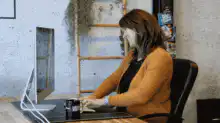 Woman typing and stretching at desk
